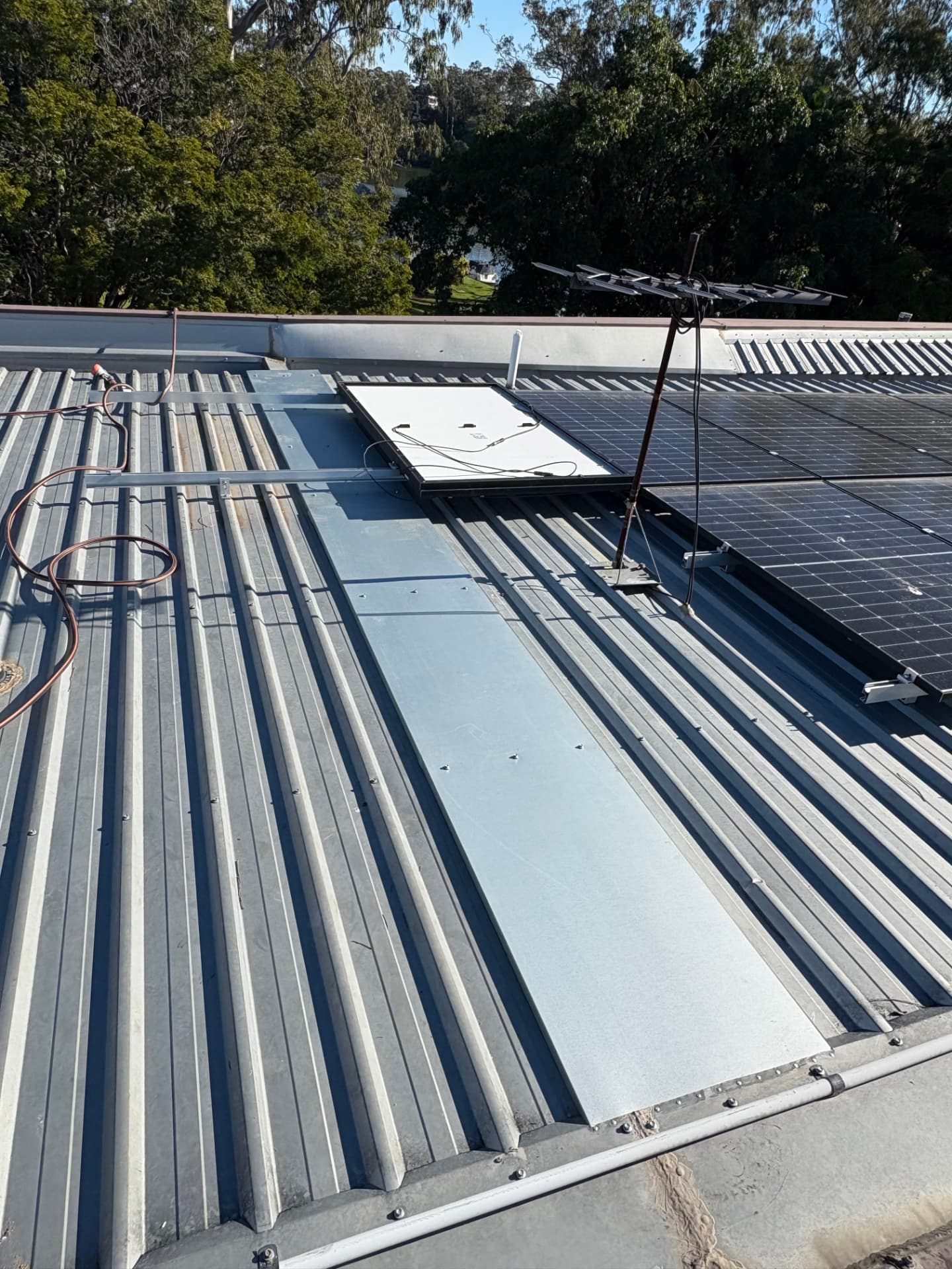 New dry pan installed over metal roof sheeting beside solar panels in Yeronga, Brisbane