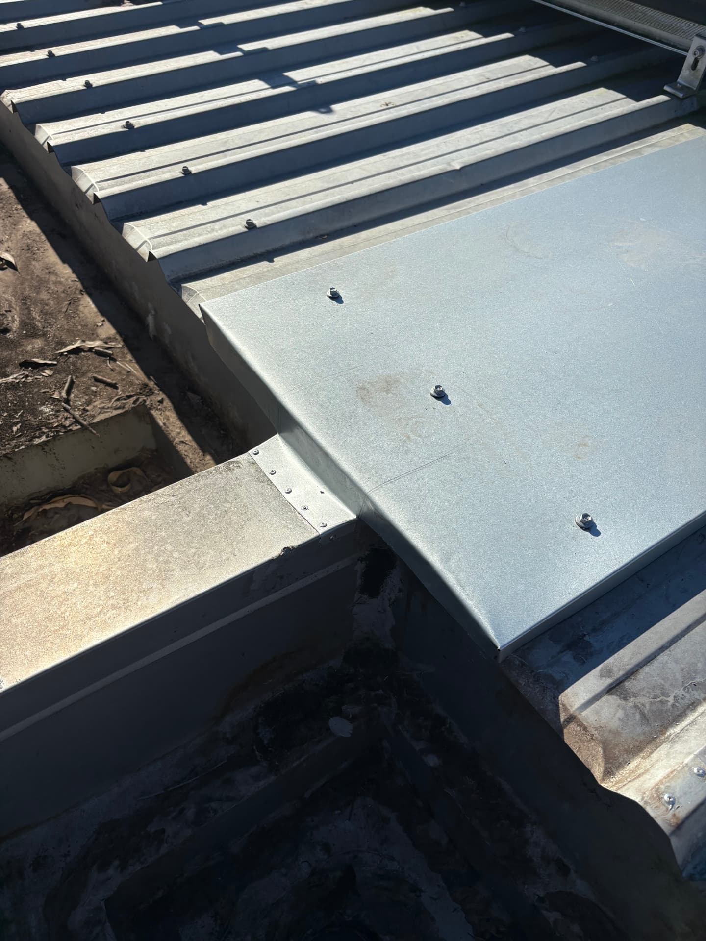 New dry pan flashing lapped over the box gutter and sealed to the saddle flashing