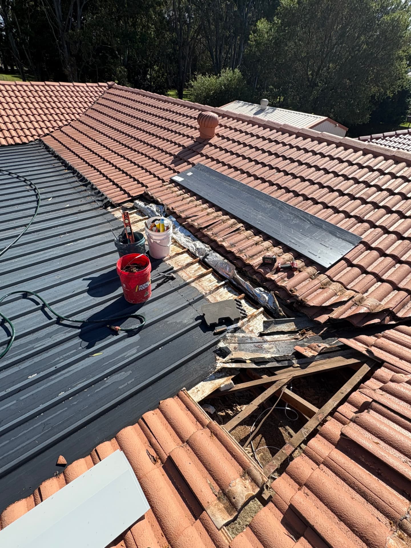 Tiles and old flashing removed along the valley with new flashing stock laid out on the roof
